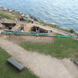 aerial view of archaeologists excavating next to a riverbank