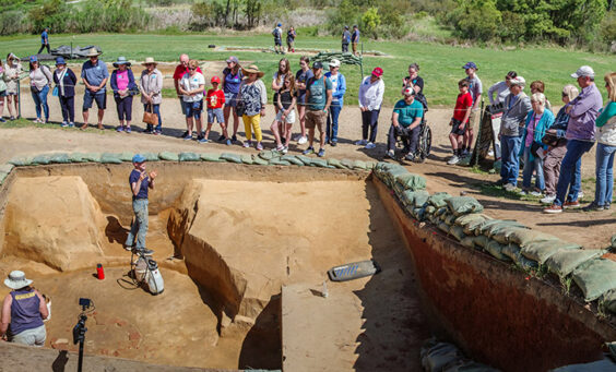 Staff Archaeologist Natalie Reid explains the excavations of the 1608 ditch and 1610s well during an archaeology tour.