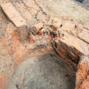 Small hole surrounded by exposed bricks