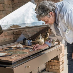 woman places artifacts in a museum case