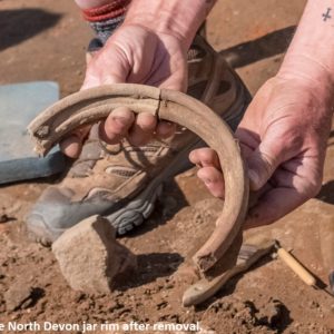 Hands holding excavated North Devon jar rim