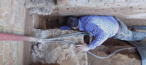 Archaeologist reaching into excavated corner