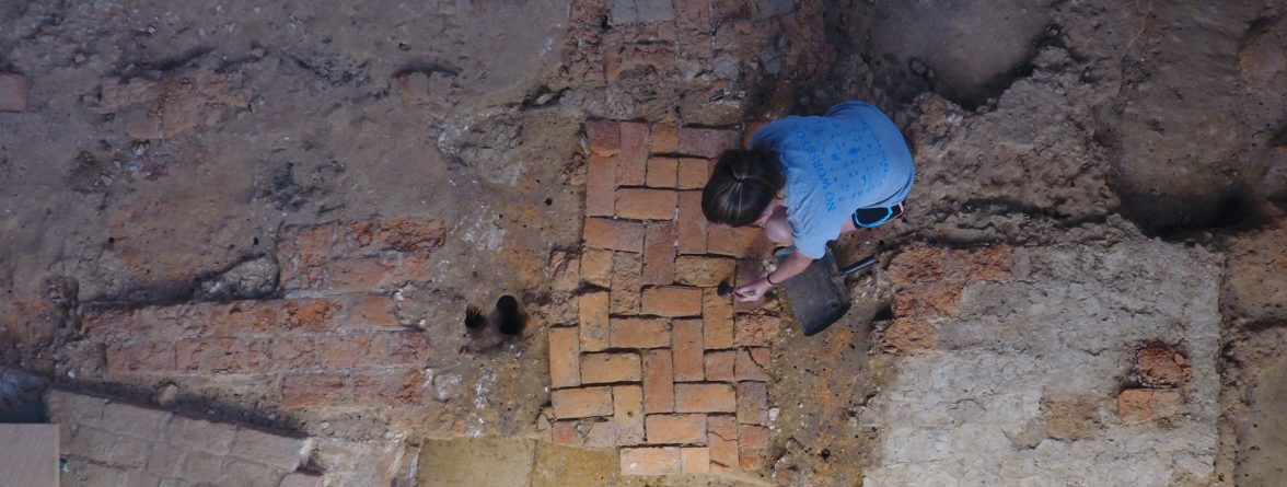 Archaeologist excavates brick floor