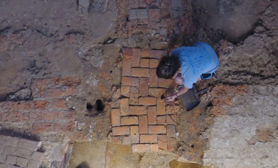 Archaeologist excavates brick floor