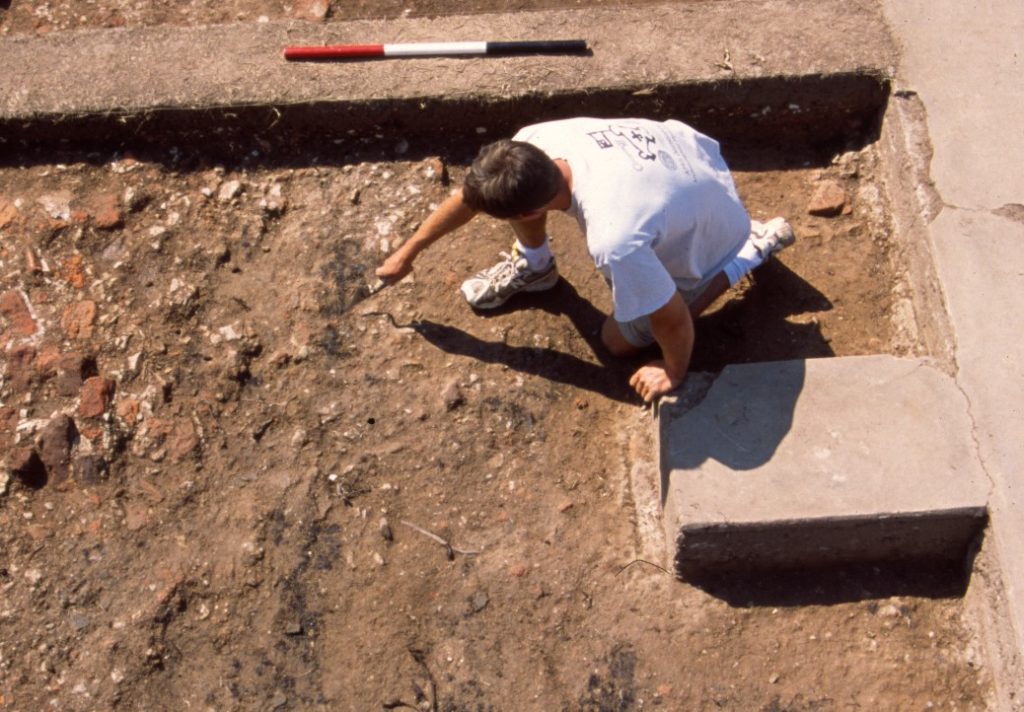 Archaeologist troweling in an excavation unit