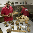 Director of Collections & Conservation Michael Lavin examines the rapier hilt.  It was one of many hilts found in the Blacksmith Shop/Bakery.