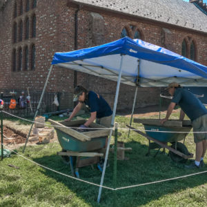 Archaeologists screen artifacts under tent