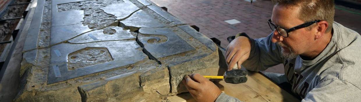 Conservator measuring a large tombstone
